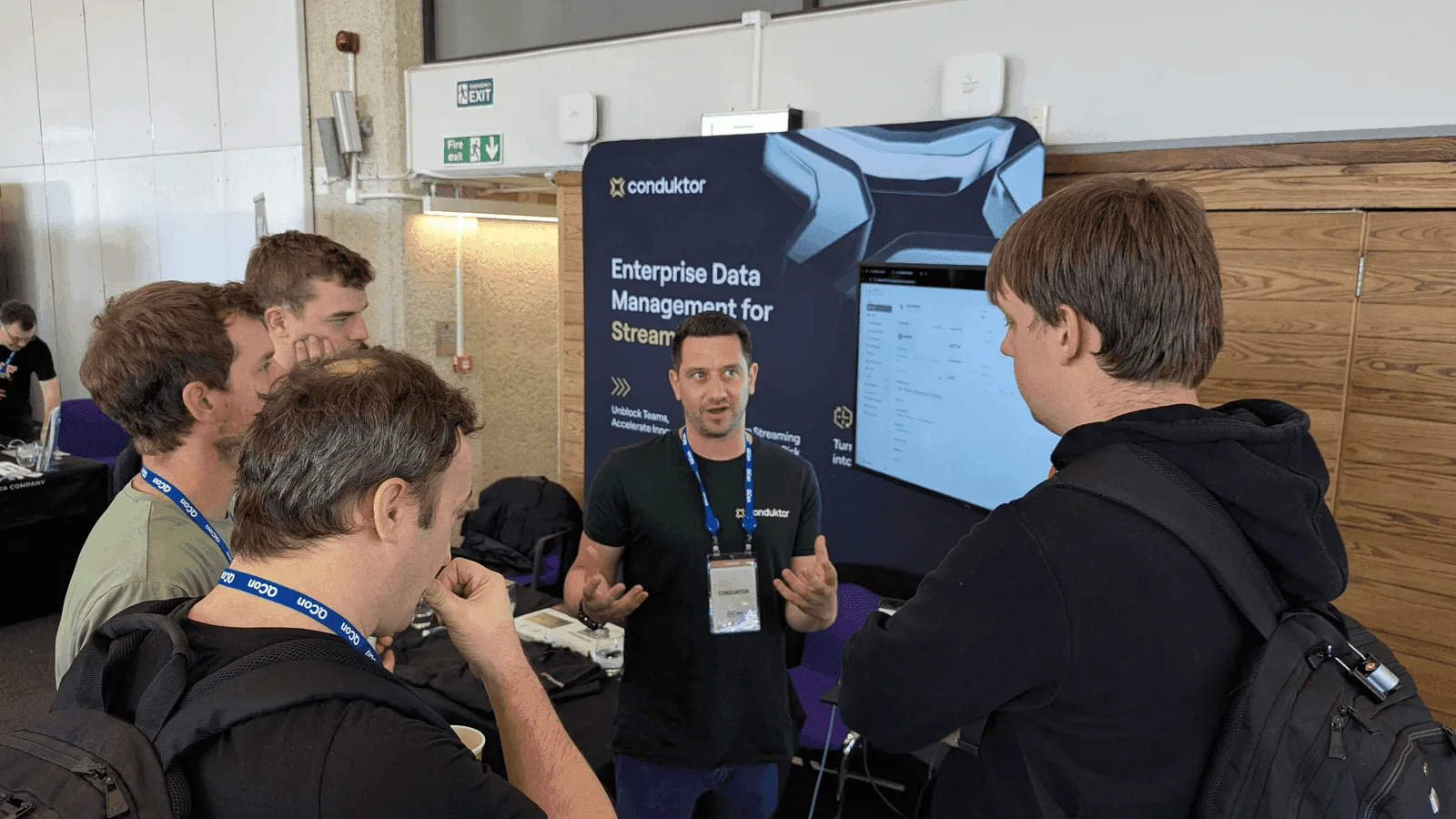 Conduktor team member discussing Enterprise Data Management for Streaming with attendees at the QCon 2025 booth